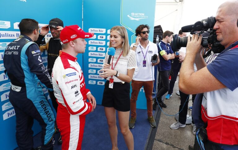 Áttetsző felsőben pózol a Formula E riporternője egy Jaguar motorháztetőjén